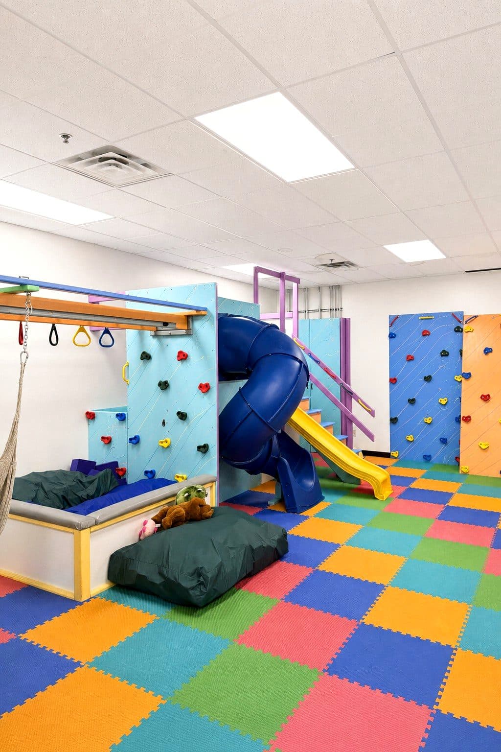 The climbing wall and swings in the sensory gym at our Eagan clinic