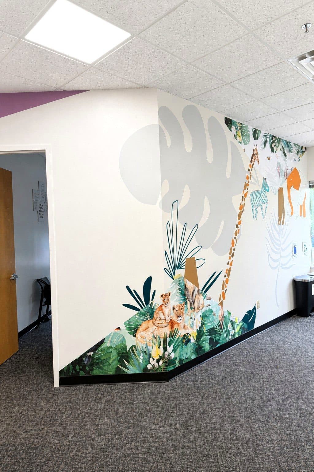 The jungle mural with a giraffe painted along a hallway of our Eagan clinic